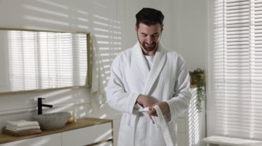 Güzel adam, bornozunu içeride bağlıyor.