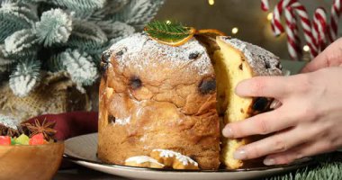 Noel yemeği. Masada nefis bir panettone pastası yiyen bir kadın, yakın plan. Bokeh etkisi