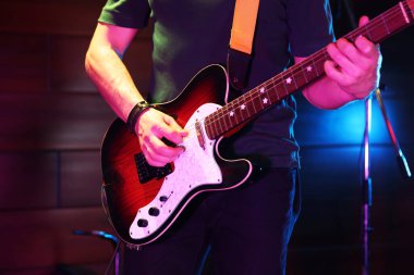 Sahnede elektro gitar çalan adam, yakın plan.