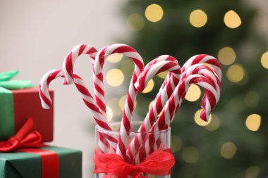 Bardaktaki şeker çubukları bulanık ışıklara karşı, yakın plan. Noel hediyesi