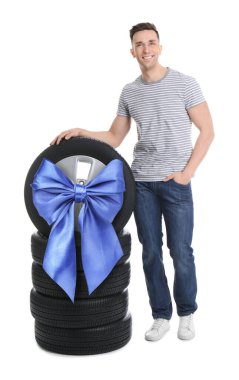 Lastik tamircisi, kurdeleli araba tekerleği ve beyaz arka planda lastikler. Özel teklif ya da indirim.