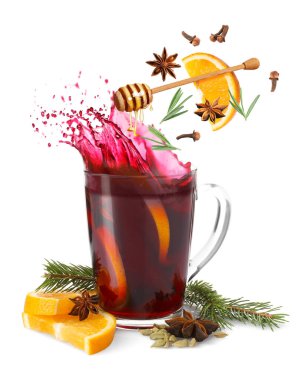 Sıcak şarap malzemeleri beyaz arka planda cam bardak sıcak içeceğe dökülüyor.