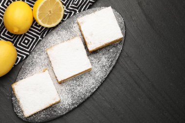 Lezzetli limonlu kekler ve siyah masada taze meyveler. Metin için boşluk