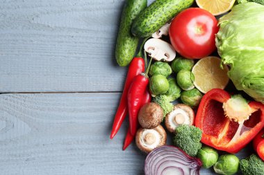 Farklı taze çiğ sebzeler ve gri ahşap masada limon. Metin için boşluk
