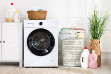Çamaşır sepetleri, çamaşır makinesi ve deterjanlar.