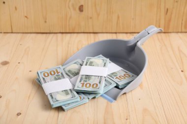 Tahta arka planda dolar banknotları olan faraş.