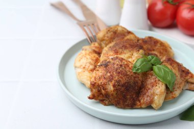 Lezzetli kavrulmuş tavuk butları ve fesleğenli beyaz fayanslı masa, yakın çekim. Metin için boşluk