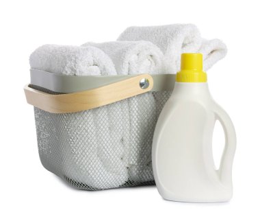 Temiz havlular ve beyaza izole edilmiş deterjan dolu çamaşır sepeti.