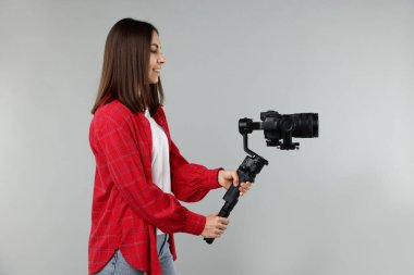 Işık arkaplanında kamera olan titreşimli dengeleyici kullanan kameraman