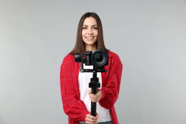 Işık arkaplanında kamera olan titreşimli dengeleyici kullanan kameraman