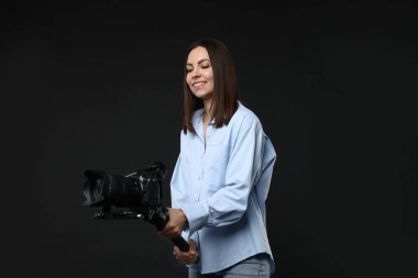 Siyah zemin üzerinde kamera olan titreşimli dengeleyici kullanan kameraman