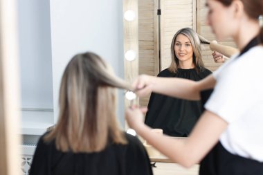 Kuaför müşterisiyle kuaförde çalışıyor.