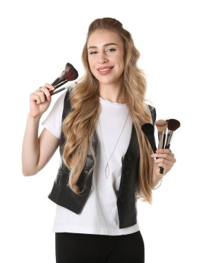 Beyaz arka planda fırça seti olan makyaj sanatçısı