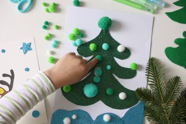 Küçük çocuk Noel kartpostalı hazırlıyor. Çocuk el yapımı.