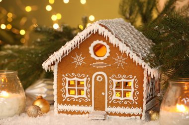 Güzel zencefilli kurabiye evi ve Noel dekoru bulanık ışıklara karşı, yakın plan. Bokeh etkisi