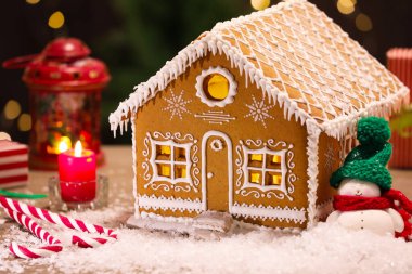 Güzel zencefilli kurabiye evi ve Noel dekoru bulanık ışıklara karşı, yakın plan