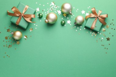 Yeşil arka planda hediyeleri ve dekorasyonu olan güzel bir Noel kompozisyonu. Metin için boşluk