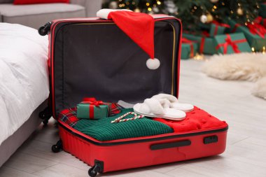 Noel tatili. İçinde Noel Baba şapkası, kıyafet, baston şekerler ve kapalı bir yerde hediye paketi var.