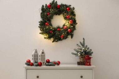 Beyaz duvarın yanındaki dolapta farklı bir Noel dekoru var.