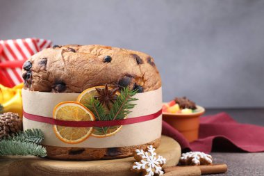 Baharatlı panettone keki, şekerli meyveler ve kahverengi masada Noel süsü, yakın plan. Metin için boşluk