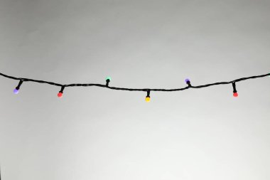 Gri arka planda parlak Noel ışıkları, yakın plan