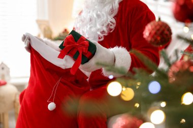 Noel Baba Noel ağacının yakınındaki çuvaldan hediyesini alıyor.