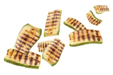 Izgara kabak parçaları beyaz arka planda havada uçuşuyor.