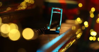 Bulanık ışıklara karşı piyano ve nota çalan kadın, yakın plan Bokeh etkisi ile. Noel atmosferi