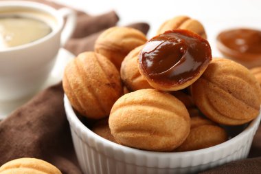 Delicious nut shaped cookies with boiled condensed milk on table, closeup