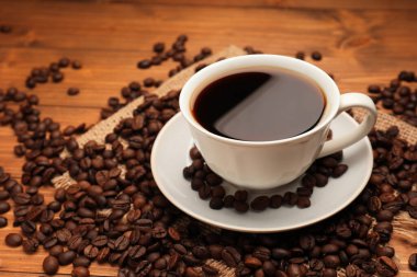 Aromatik kahve fincanda, fasulye de ahşap masada, yakın plan. Metin için boşluk