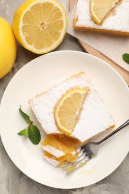 Nane ve taze meyveli lezzetli limonlu kekler gri mermer masada, düz uzanmış.