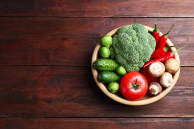 Tahta masadaki kasede farklı taze taze sebzeler, üst manzara. Metin için boşluk