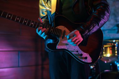 Sahnede elektro gitar çalan adam, yakın plan.