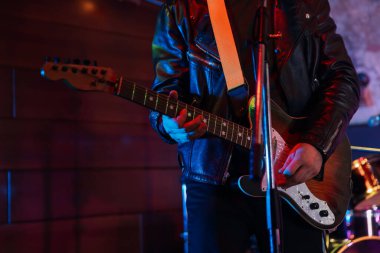 Sahnede elektro gitar çalan adam, yakın plan.