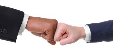 Beyaz arka planda iş ortağıyla yumruklaşan Afrikalı Amerikalı bir adam.