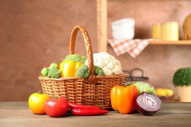 Farklı taze taze sebzeler hasır sepet içinde ahşap masa içinde.