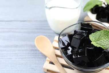 Tasty herbal jelly, mint and milk on grey wooden table, closeup. Space for text