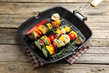 Grill pan with tasty vegetables on wooden table, closeup