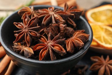 Mulled wine spices. Anise stars in bowl on table, closeup