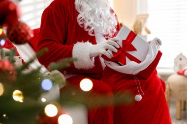 Noel Baba Noel ağacının yakınındaki çuvaldan hediyesini alıyor.