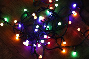 Parlak Noel ışıkları ahşap masanın üzerinde, karanlıkta, üst manzarada.