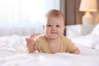 Evde yatağında biberonla beslenen tatlı bir bebek. Metin için boşluk