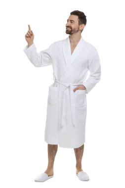 Bornozlu adam beyaz arka planda bir şeye bakıyor.