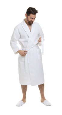 Bornoz kemerini beyaz arka planda bağlayan adam