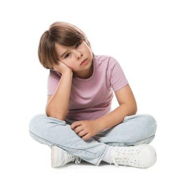 Üzgün küçük çocuk beyaz arka planda oturuyor.