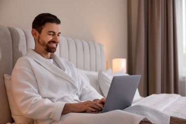 İçerde dizüstü bilgisayarla çalışan bornozlu yakışıklı bir adam. Metin için boşluk