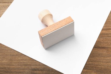 Masaya bir tahta pul ve boş bir kağıt, yakın plan. Metin için boşluk