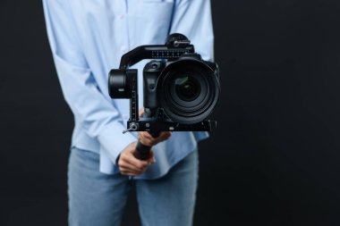 Siyah arkaplanda kamera olan titreşim sabitleyici kullanan kameraman, yakın plan