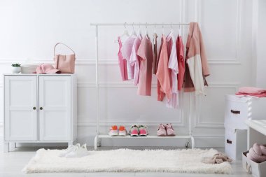 Askıda asılı farklı şık kıyafetler, aksesuarlar ve ayakkabılar.