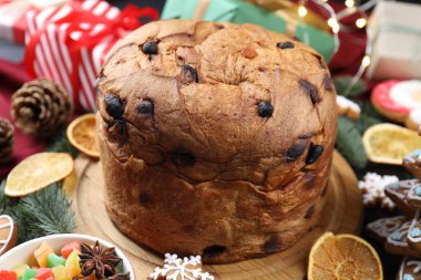 Lezzetli panettone keki, zencefilli kurabiye, baharatlar, şekerli meyveler ve Noel süsü, yakın plan.